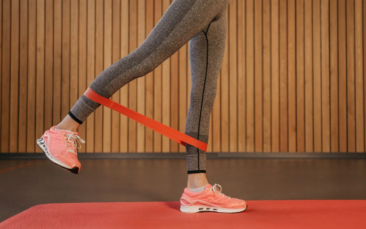 Exercice d'abduction de hanche avec élastique de résistance pour renforcer le moyen fessier du coureur