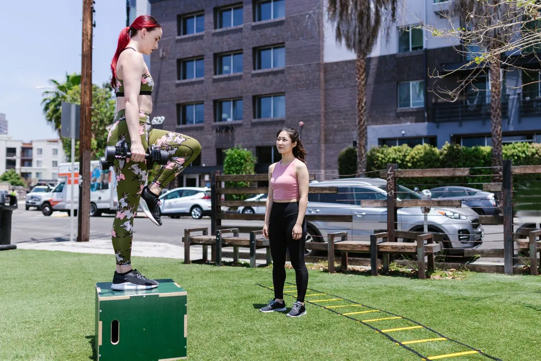 Femmes réalisant des montées sur step en extérieur, un exercice de renforcement sur une jambe pour coureur
